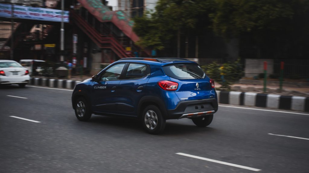 Renault Kwid 2024 driving through a busy urban street