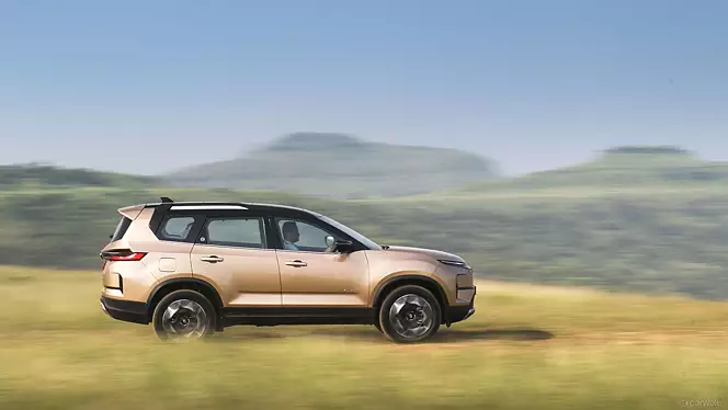 Tata Safari 2024 driving through a rugged terrain.